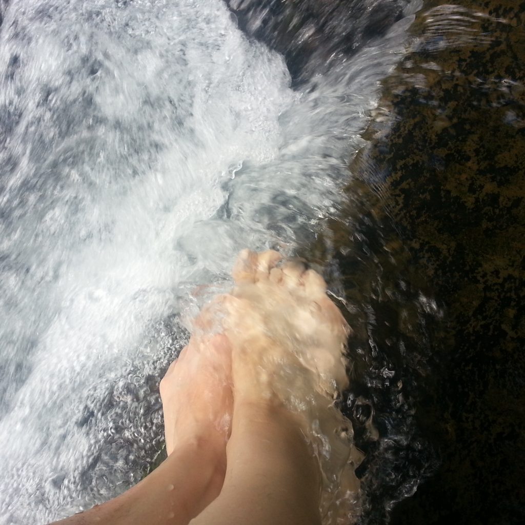 bare feet in creek cascade